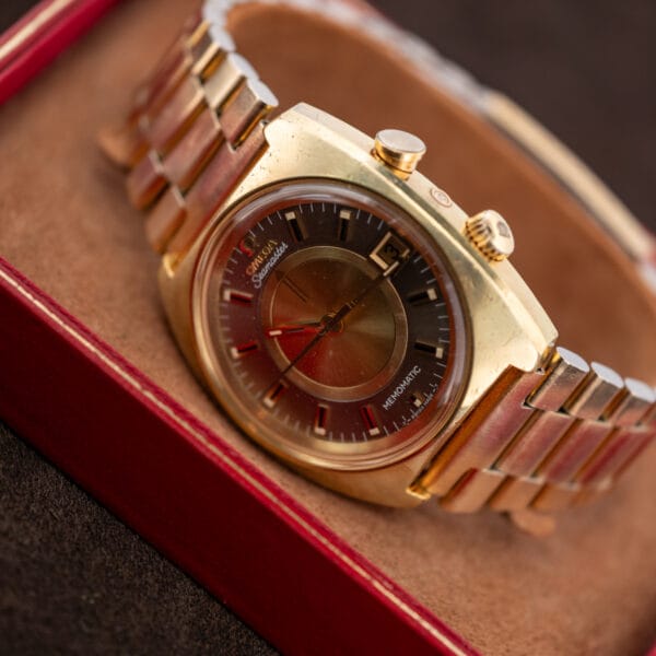 Omega Seamaster Memomatic 166.072 angled on a tan display support with its linked bracelet curved behind