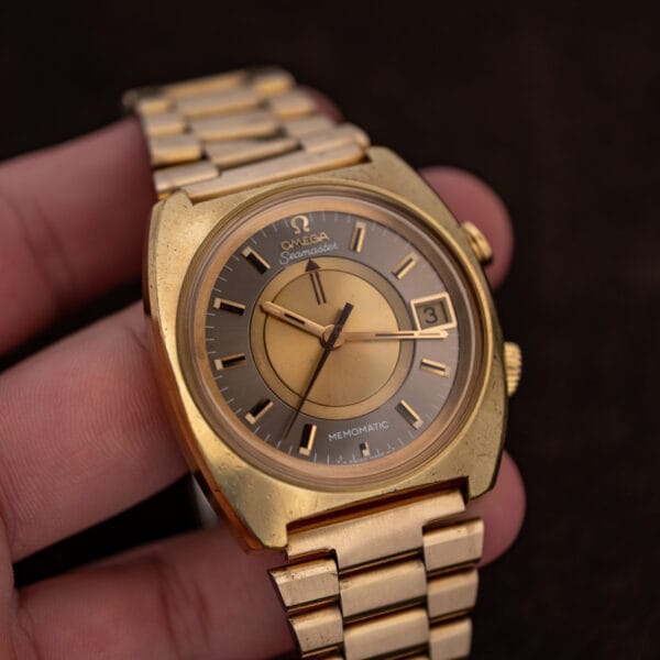 Hand-held Omega Seamaster Memomatic 166.072 upright with curved bracelet, baton hands and date window visible