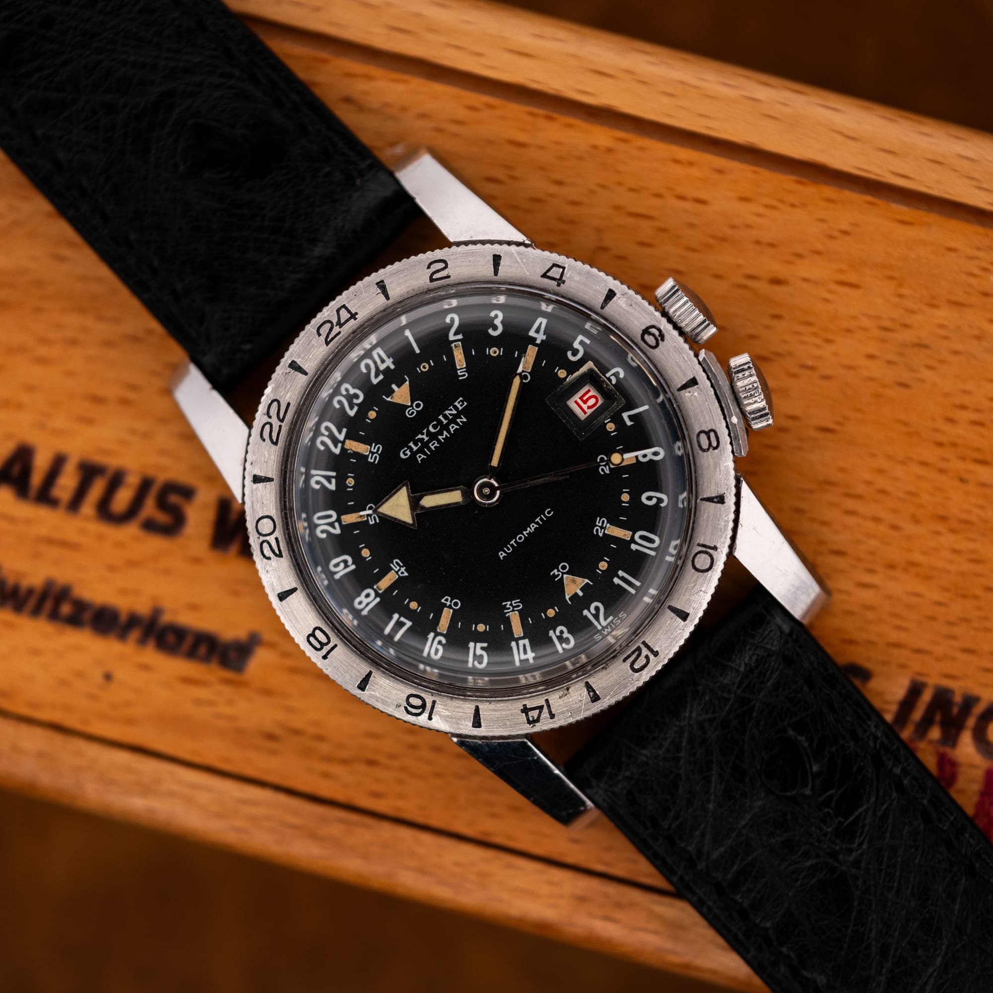 DSCF7333 Glycine Airman on its black ostrich strap, resting diagonally across a wooden box with the dial visible