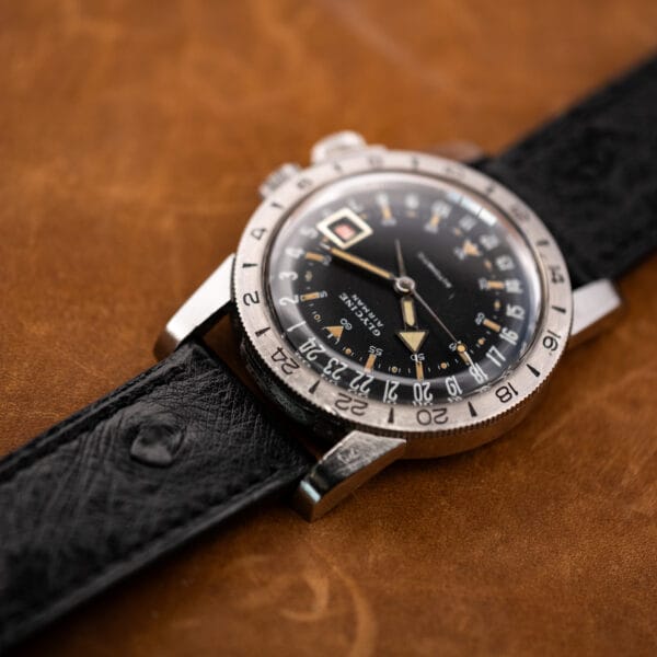 Glycine Airman viewed from the opposite side, with its 24-hour bezel and textured black ostrich strap in focus