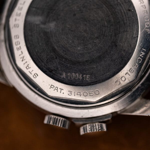 Glycine Airman caseback detail showing the A100415 marking, patent number and edge of the two crowns