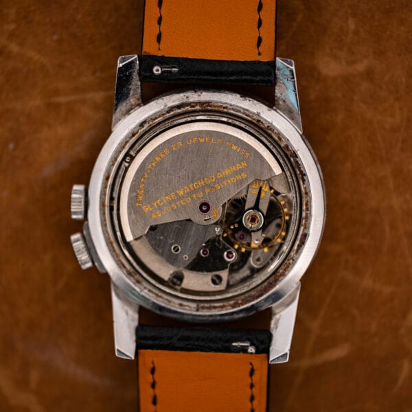 Open Glycine Airman case revealing the automatic movement, signed rotor and balance beside the strap undersides