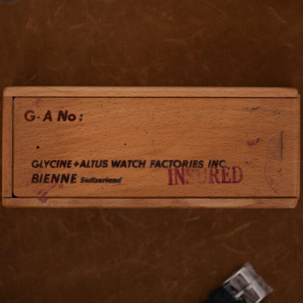 Wooden Glycine and Altus presentation box with printed factory lettering and postal markings across its sliding lid