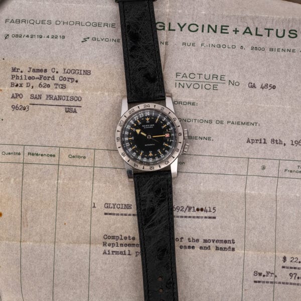 Glycine Airman and extended black ostrich strap resting on a Glycine and Altus invoice with typed entries
