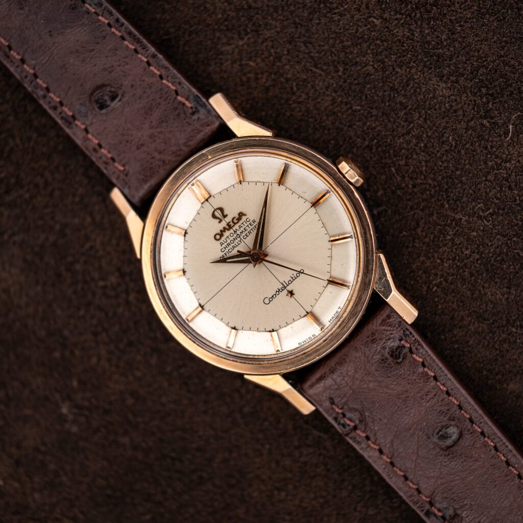 Omega Constellation 167.005 with silver crosshair pie pan dial, rose gold capped case, and brown ostrich strap