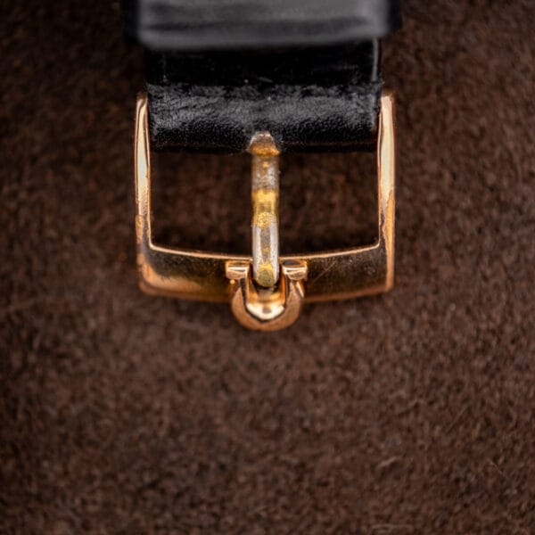Front detail of the Omega emblem buckle on the separate black strap accompanying Constellation 167.005 photography