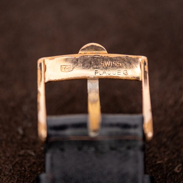 Rear of the separate Omega buckle showing SWISS and PLAQUE G stamps beside its maker mark