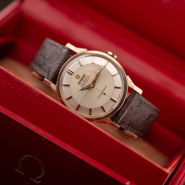Omega Constellation 167.005 resting inside an open red presentation box with its brown ostrich strap