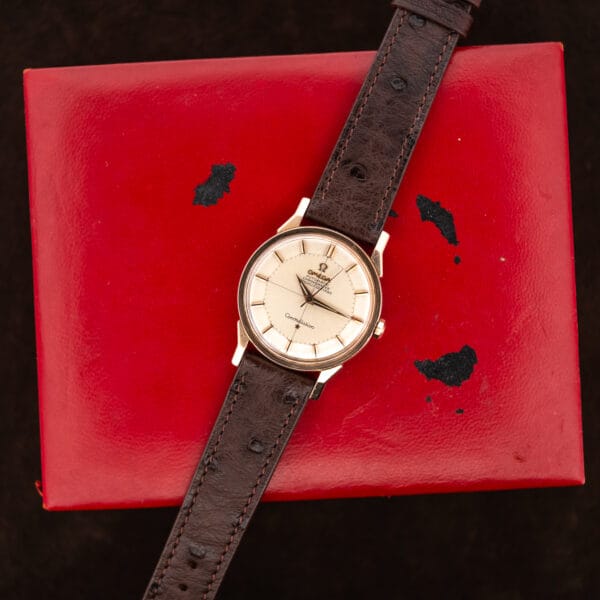 Omega Constellation 167.005 arranged across the worn red exterior of its presentation box