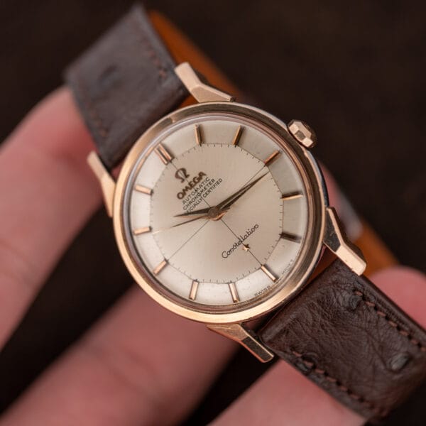 Handheld angled Omega Constellation 167.005 with silver pie pan dial, applied star, and faceted crown