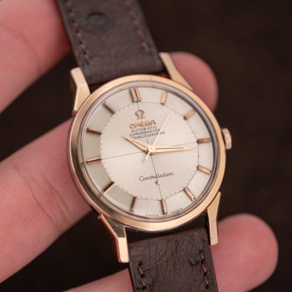 Handheld front detail of Omega Constellation 167.005 displaying dauphine hands and a no date crosshair dial