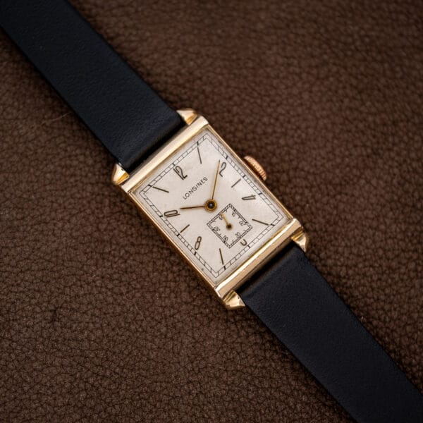 Overhead view of the Longines rectangular watch with its black leather strap extended diagonally