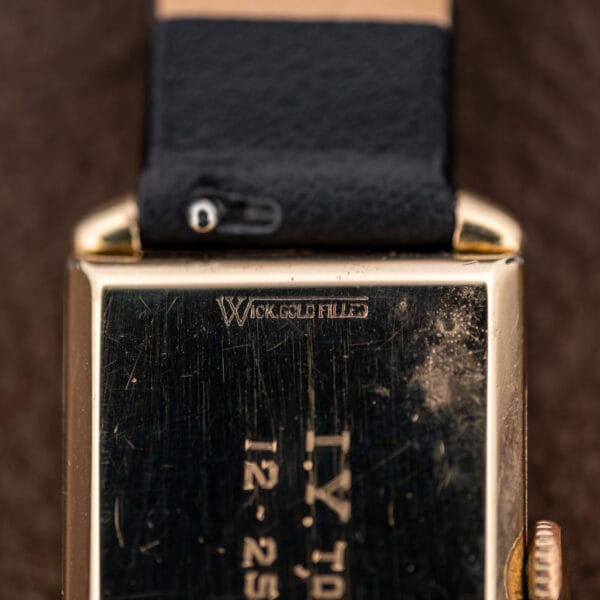 Longines caseback detail showing the W emblem and 10K.GOLD FILLED stamp beside the leather strap