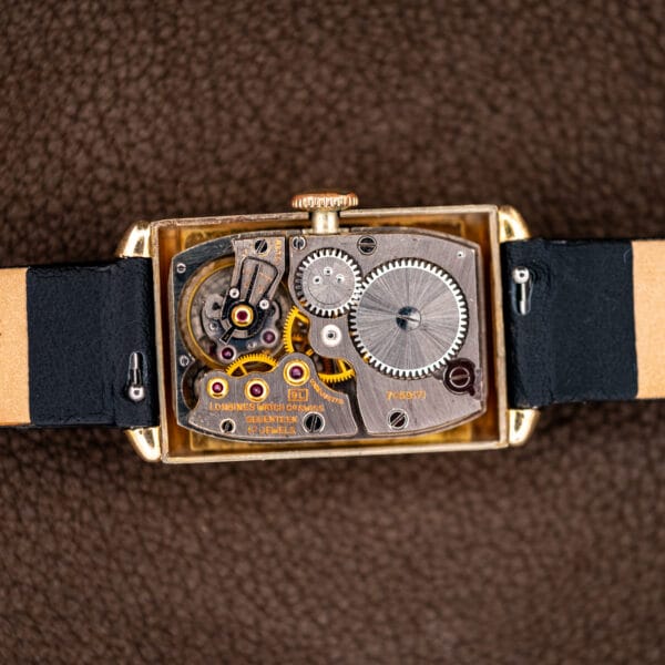 Open Longines tank showing the rectangular caliber 9L manual-wind movement and its winding wheels