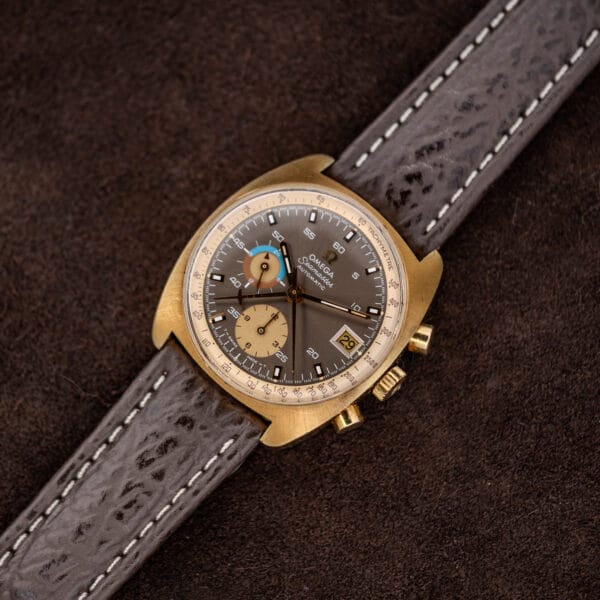 Full length diagonal view of Omega 176.007 with gold plated cushion case and stitched brown strap