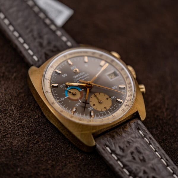 Omega Seamaster 176.007 angled face showing sunburst texture, gold toned hands, and contrasting subdials