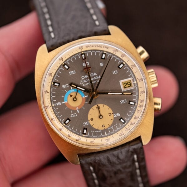 Handheld front view of Omega Seamaster 176.007 chronograph with date aperture and mocha sunburst dial