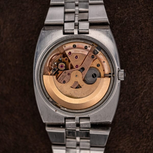 Omega caliber 751 movement exposed beneath the removed Constellation caseback, with broad winding rotor