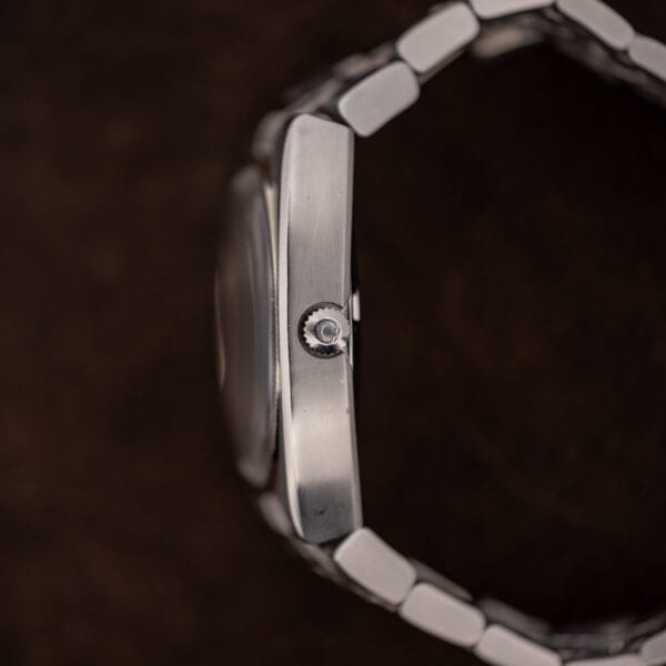 Crown-side profile of Omega Constellation 168.045 showing signed crown, raised crystal and curved bracelet