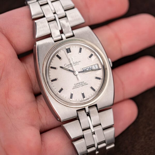 Omega Constellation 168.045 resting in an open palm with silver day-date dial and steel bracelet
