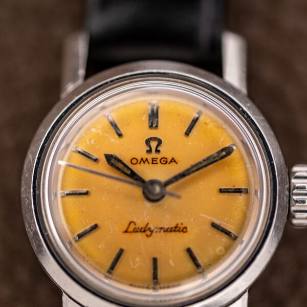 Omega Ladymatic lemon dial detail with double twelve marker, pointed hands and applied baton indices