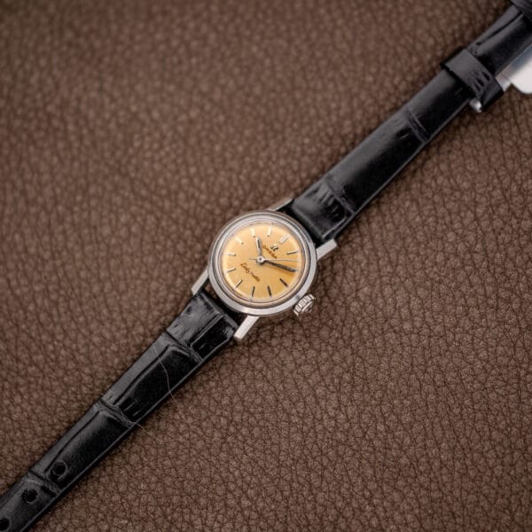 Full Omega Ladymatic 11000 SC laid diagonally on its extended black patterned leather strap