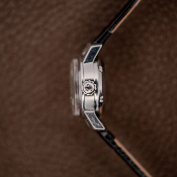 Omega Ladymatic crown-side profile with signed ridged crown, projecting lugs and raised domed crystal