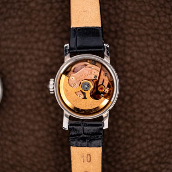 Open Ladymatic 11000 SC case revealing the signed Omega winding rotor and movement beneath