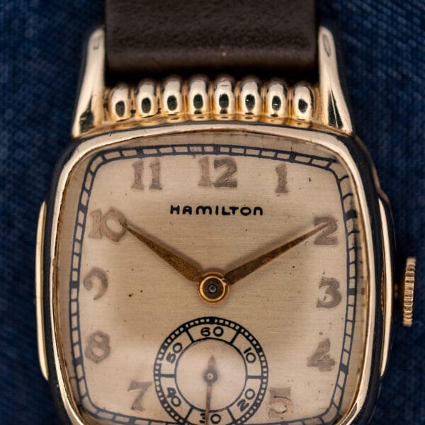 Hamilton Roland upper dial close-up showing applied numerals, stylized signature and rounded decorative case ribs