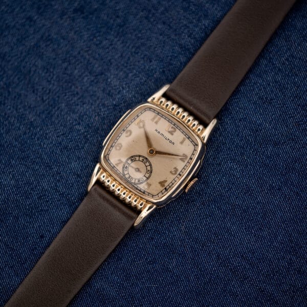 Diagonal Hamilton Roland portrait showing gold filled rectangular case and full brown leather strap