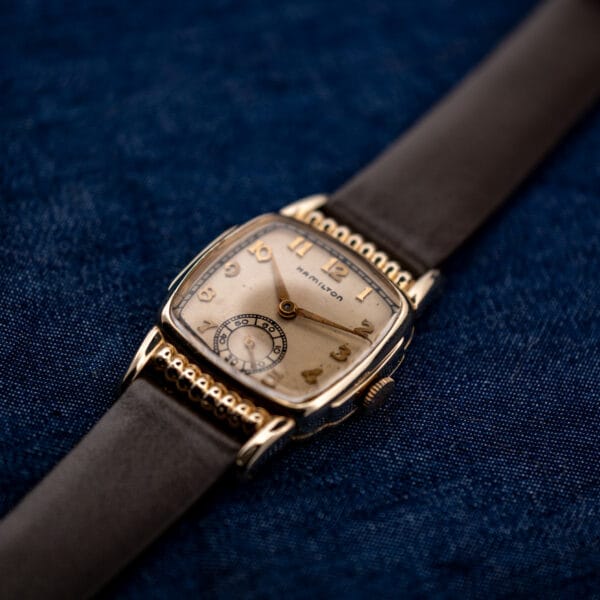 Low angled Hamilton Roland dial view highlighting applied Arabic numerals and rounded ribbed case ends