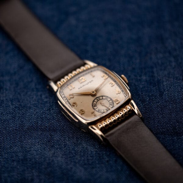 Three-quarter Hamilton Roland front with circular seconds register and decorative ribs beside brown leather strap