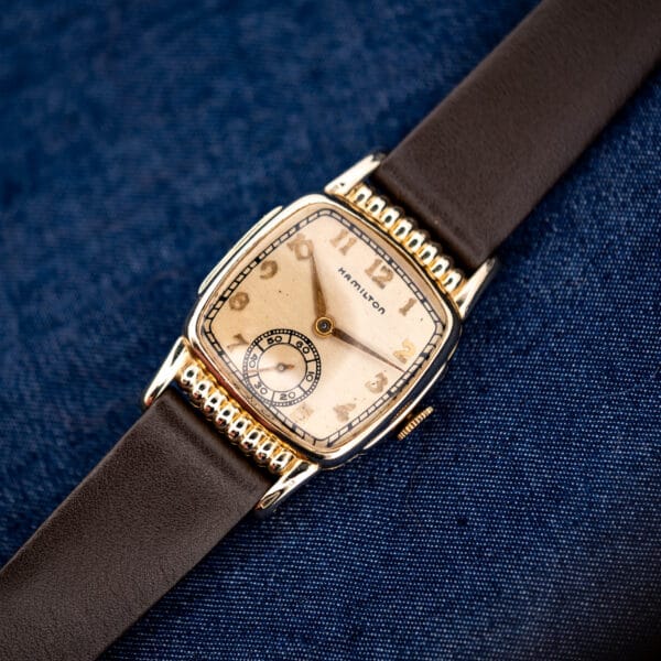 Hamilton Roland diagonal close-up with silver dial, gold-tone hands and fixed pointed case lugs