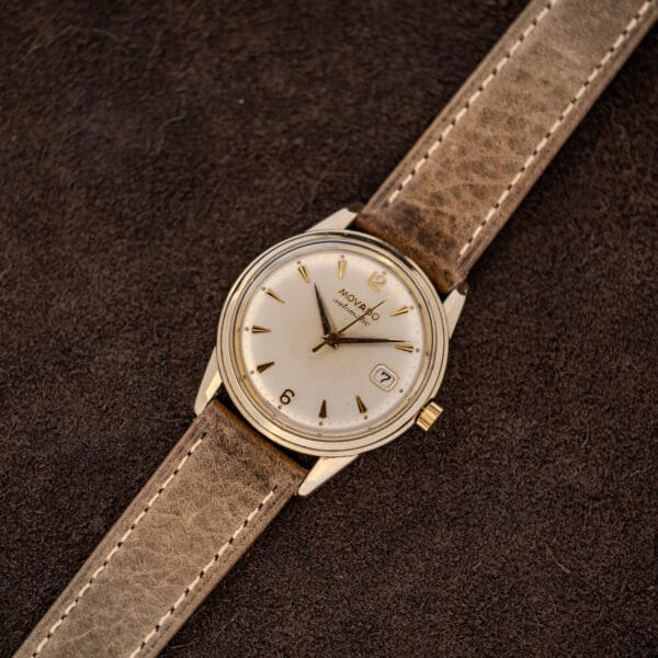 Complete Movado 64389 displayed diagonally with stitched leather strap and applied hour markers