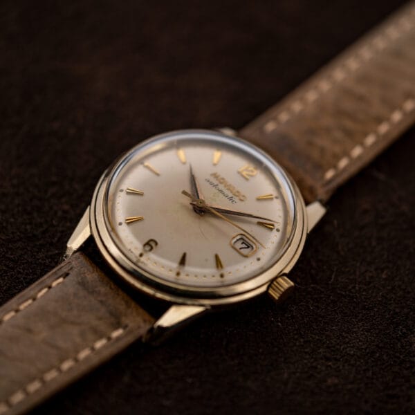 Low angled Movado Automatic view highlighting domed crystal and stepped round bezel