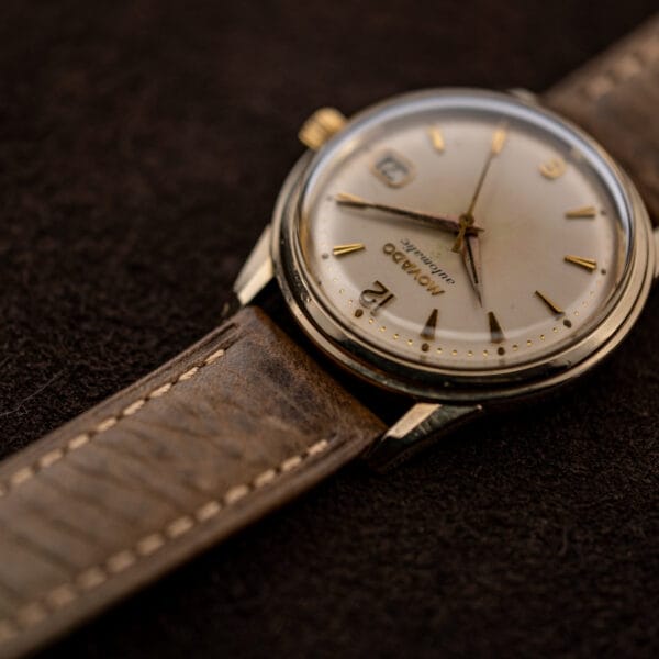 Oblique Movado Automatic view with raised crystal, faceted hour markers and tapered lugs
