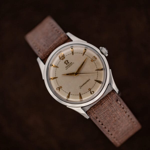 Diagonal front view of Omega Seamaster 2635-9 SC against dark fabric with brown textured strap