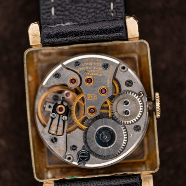 Close-up of signed Longines mechanical movement showing jeweled bridges, winding wheels and boxed caliber marking