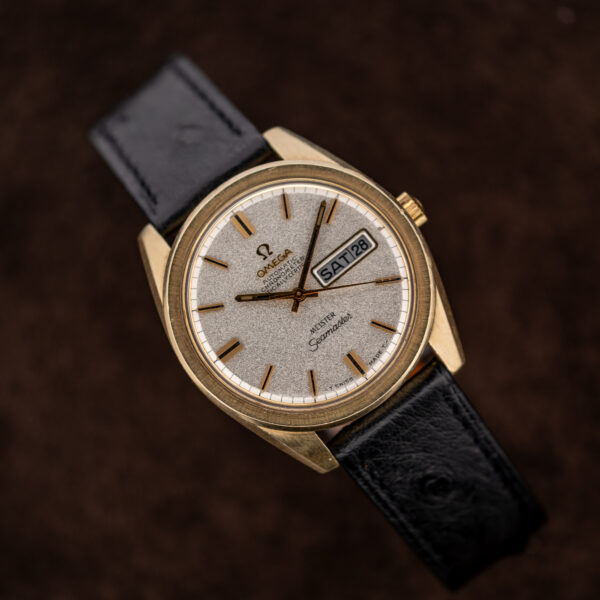 Omega Seamaster Meister presented with curved black ostrich strap and visible day-date display at three