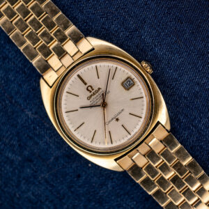 Omega Constellation 168.017 overhead view with silver dial, framed date and linked bracelet on navy fabric