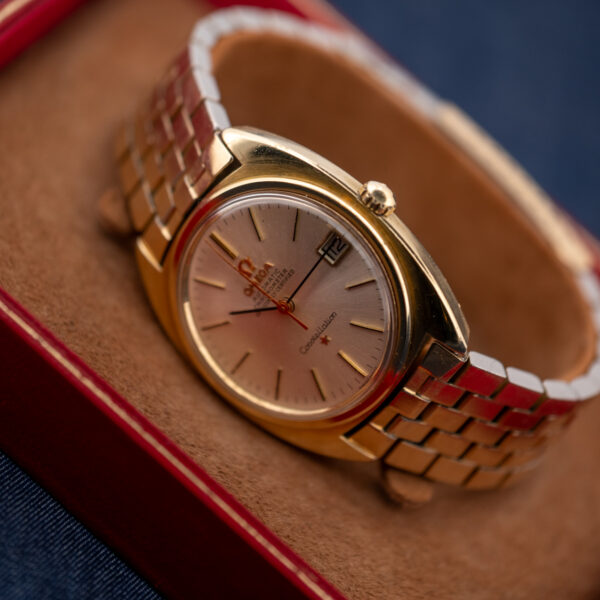 Omega Constellation 168.017 angled display with framed date and bracelet resting on a tan support