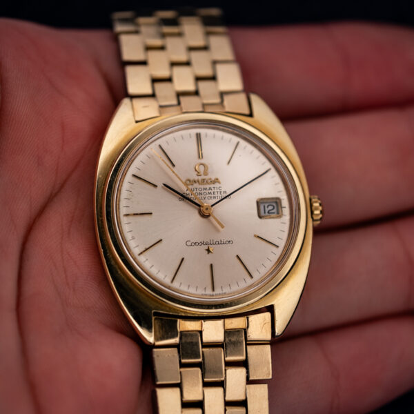 Omega Constellation 168.017 held in a hand, showing silver dial, applied star and bracelet