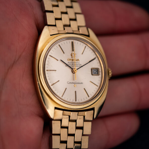 Omega Constellation 168.017 handheld angled view highlighting rounded case edges and rectangular bracelet links