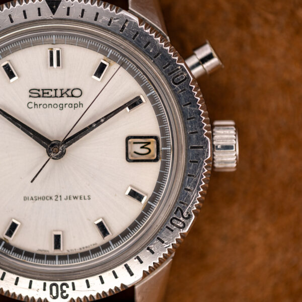 Seiko chronograph close-up from the crown side, showing the single pusher above the crown and the date window
