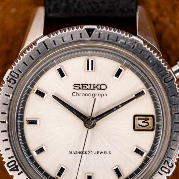 Close-up of the Seiko chronograph dial with the SEIKO Chronograph signature, baton hour markers and date window at three