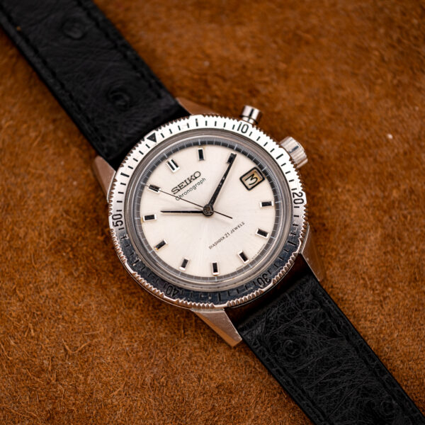 Front view of the vintage Seiko chronograph showing the white dial, date at three and numbered timing bezel