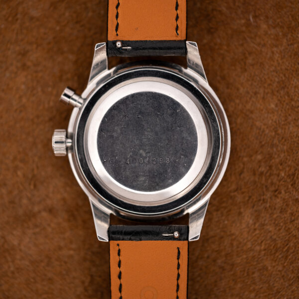 Back of the Seiko 5717-8990 case with a faint caseback number, scratched steel and orange-lined black strap