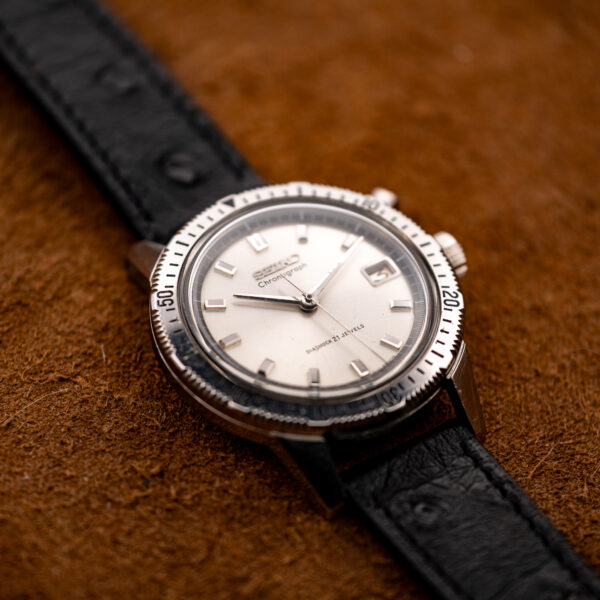 Low angle on the Seiko 5717-8990 showing the raised crystal over the white dial and the black strap