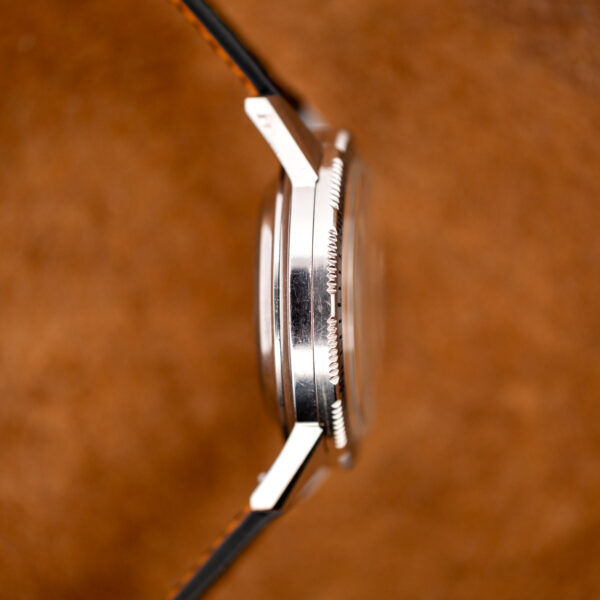 Seiko chronograph case in profile from the opposite side, showing the raised crystal and toothed bezel edge