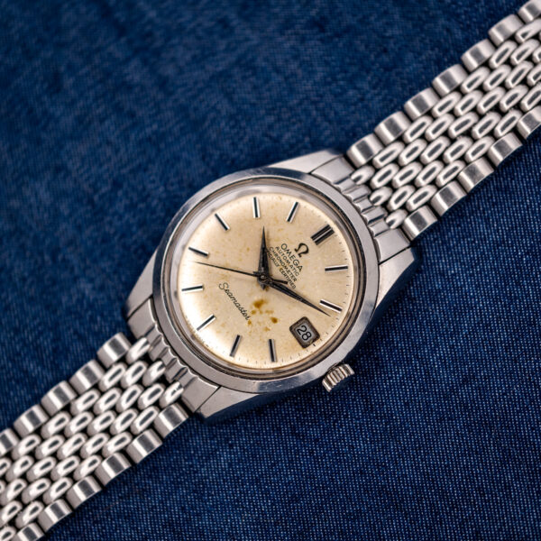 Omega Seamaster 166.010 wide overhead arrangement with date dial and stainless steel bracelet extending diagonally